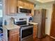 Well-maintained kitchen with stainless steel appliances, wooden cabinets, and laminate countertops at 10945 Sw 75Th Ave, Ocala, FL 34476
