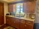 Kitchen featuring wood cabinets, stainless sink and faucet with a view out of the window at 10945 Sw 75Th Ave, Ocala, FL 34476