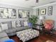 Comfortable living room featuring a large grey couch, ottoman, artwork, and a decorative plant at 10945 Sw 75Th Ave, Ocala, FL 34476