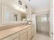 Bright bathroom featuring a double vanity and a large shower with glass doors at 12489 Se 90Th Ter, Summerfield, FL 34491
