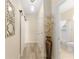 Bright hallway with wood-look flooring, decorative mirror, and access to bathroom with white fixtures at 12489 Se 90Th Ter, Summerfield, FL 34491