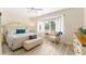 Bright main bedroom with a ceiling fan, bench, lots of natural light, and light colored walls at 12489 Se 90Th Ter, Summerfield, FL 34491