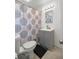 Well-lit bathroom featuring a coordinated vanity, mirror, and patterned shower curtain at 1330 Ne 55Th St, Ocala, FL 34479
