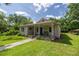 Attractive home features a quaint covered porch with a bench and a lush green lawn at 1330 Ne 55Th St, Ocala, FL 34479