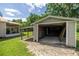 Backyard view of an open garage structure with a weathered concrete floor at 1330 Ne 55Th St, Ocala, FL 34479