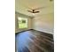 This bedroom features a ceiling fan, natural light, and beautiful dark wood floors at 13305 Sw 114Th Pl, Dunnellon, FL 34432