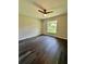This bedroom features a ceiling fan, natural light, and beautiful dark wood floors at 13305 Sw 114Th Pl, Dunnellon, FL 34432