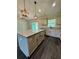 Stylish kitchen with an island, stainless steel appliances, and sleek gray wood flooring at 13305 Sw 114Th Pl, Dunnellon, FL 34432