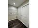 A compact laundry room with dark wood floors and wire shelving for optimal storage and organization at 13305 Sw 114Th Pl, Dunnellon, FL 34432