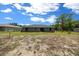 The back of the property with a yard and lush greenery and access to an enclosed area at 13479 Sw 100Th Ln, Dunnellon, FL 34432