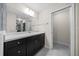 Well-lit bathroom featuring dark cabinetry, a large mirror, and convenient access to a walk-in closet at 13479 Sw 100Th Ln, Dunnellon, FL 34432