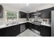 Well-equipped kitchen with stainless steel appliances, dark cabinetry, and a view of the outdoors at 13479 Sw 100Th Ln, Dunnellon, FL 34432