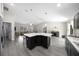An open-concept kitchen boasts a modern island, gray vinyl floors, and plenty of natural light at 13479 Sw 100Th Ln, Dunnellon, FL 34432