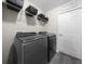 Laundry room featuring a washer, dryer, overhead storage, and utility door at 13479 Sw 100Th Ln, Dunnellon, FL 34432