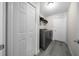 The laundry room includes shelving, washer and dryer, and a utility door at 13479 Sw 100Th Ln, Dunnellon, FL 34432
