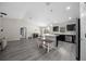 Bright, open-concept living space featuring kitchen, dining, and lounge areas with continuous gray vinyl flooring at 13479 Sw 100Th Ln, Dunnellon, FL 34432