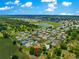 Aerial view of a neighborhood with mature trees and a community lake at 13835 Se 85Th Cir, Summerfield, FL 34491