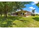Backyard view showing the screened patio, trees and manicured lawn at 13835 Se 85Th Cir, Summerfield, FL 34491