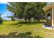Expansive backyard featuring lush green grass and mature trees offering ample shade and privacy at 13835 Se 85Th Cir, Summerfield, FL 34491