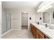 Bathroom boasting double sinks, tiled floors, a glass-enclosed shower, and a walk-in closet at 13835 Se 85Th Cir, Summerfield, FL 34491