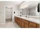 Bathroom with double sinks, tiled floors, a glass-enclosed shower, and a walk-in closet at 13835 Se 85Th Cir, Summerfield, FL 34491