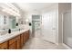 Bathroom featuring double sinks, a large mirror, and an open doorway to another room at 13835 Se 85Th Cir, Summerfield, FL 34491