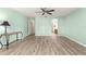 Bedroom with neutral walls, wood-look floors, ceiling fan, and doors leading to additional rooms at 13835 Se 85Th Cir, Summerfield, FL 34491