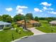 Charming single-story home with a well-manicured lawn, mature landscaping, and a long driveway leading to a two-car garage at 13835 Se 85Th Cir, Summerfield, FL 34491