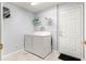 Functional laundry room including washer, dryer, and door to the outside at 13835 Se 85Th Cir, Summerfield, FL 34491