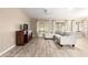 Open-concept living room featuring hardwood floors, a comfortable sofa, and plenty of natural light at 13835 Se 85Th Cir, Summerfield, FL 34491