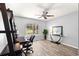 Home office with a ceiling fan, desk, and large window offering pleasant outdoor views at 13835 Se 85Th Cir, Summerfield, FL 34491