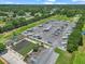 Aerial view of a community lot with RV parking, bocce ball, and manicured lawns against a backdrop of mature trees at 1443 Sw 161St St, Ocala, FL 34473