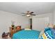 Cozy bedroom showcasing a ceiling fan, dresser, and patterned bedding at 1443 Sw 161St St, Ocala, FL 34473