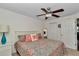 Comfortable bedroom with a patterned bedspread, ceiling fan, and a bright window view at 1443 Sw 161St St, Ocala, FL 34473
