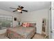 Cozy bedroom featuring a patterned bedspread, ceiling fan, and natural light from the window at 1443 Sw 161St St, Ocala, FL 34473