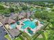 A large community pool with lounge chairs and shady umbrellas, is surrounded by lush landscaping at 1443 Sw 161St St, Ocala, FL 34473