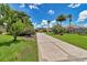 Long decorative driveway leading to a well-maintained home with vibrant green lawn and mature trees at 1443 Sw 161St St, Ocala, FL 34473