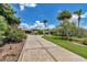 View of a patterned driveway, colorful flowerbeds, and verdant lawns in front of an elegant home at 1443 Sw 161St St, Ocala, FL 34473