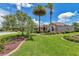 Landscaped home exterior with lush green lawn, flower beds, and palm trees creating a tropical oasis at 1443 Sw 161St St, Ocala, FL 34473