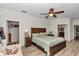 Serene main bedroom boasts wood floors, a ceiling fan, and access to the bathroom and closet at 1443 Sw 161St St, Ocala, FL 34473