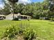 Expansive backyard with mature trees, a shed, and a screened-in porch, perfect for relaxation and outdoor activities at 1523 Se 80Th St, Ocala, FL 34480