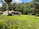 Expansive backyard with lush lawn, mature trees, a shed, and a screened-in porch, perfect for relaxation at 1523 Se 80Th St, Ocala, FL 34480