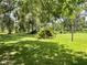 Lush green backyard shaded by mature trees creating a tranquil atmosphere and a great place to unwind at 1523 Se 80Th St, Ocala, FL 34480