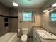 Updated bathroom featuring a granite countertop and tiled shower with built-in shelves at 1523 Se 80Th St, Ocala, FL 34480
