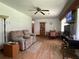 Cozy living room features wood-look flooring, a ceiling fan, and comfortable seating arrangements at 1523 Se 80Th St, Ocala, FL 34480