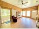 Bright living room with wood paneling, a brick fireplace, and sliding doors to an enclosed porch at 1523 Se 80Th St, Ocala, FL 34480