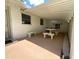 Covered patio area featuring a dining table with stone benches for seating and a privacy wall at 1523 Se 80Th St, Ocala, FL 34480