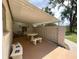 Covered outdoor patio with a concrete block privacy wall, decorated with potted plants and a picnic table at 1523 Se 80Th St, Ocala, FL 34480