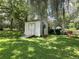 A white shed in the backyard with a ramp that could be used as a workshop or for outdoor storage at 1523 Se 80Th St, Ocala, FL 34480