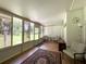 Bright sunroom with wood floors and large windows overlooking the green outdoors at 1523 Se 80Th St, Ocala, FL 34480